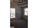 Bedroom featuring neutral carpet, tray ceiling and dual windows with wooded views at 25 Dove Pt, Covington, GA 30016