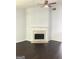 Bright living room featuring a decorative fireplace, ceiling fan and dark wood-look floors at 25 Dove Pt, Covington, GA 30016