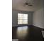 Living room featuring dark floors, a ceiling fan and a window with wooded views at 25 Dove Pt, Covington, GA 30016