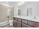 Bathroom featuring a double vanity, large mirror, and glass-enclosed shower for a spa-like experience at 1516 Parks Edge Nw Ln, Atlanta, GA 30318