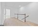 Bright hallway with carpeted floors, white walls, and wooden banister at 1516 Parks Edge Nw Ln, Atlanta, GA 30318