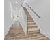 Inviting entryway featuring wood-look flooring and a staircase with carpeted steps and a stylish wooden handrail at 1516 Parks Edge Nw Ln, Atlanta, GA 30318