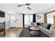 Comfortable living room with modern ceiling fan, wood flooring, and an adjacent dining area at 6490 Cainwood Dr, Atlanta, GA 30349