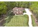 Aerial view of a stunning brick home with lush landscaping, a long driveway, and a well-manicured lawn at 20 Allie Dr, Mcdonough, GA 30252