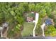 Aerial view of a grand estate surrounded by dense trees and an expansive lawn, as well as two neighbor homes at 20 Allie Dr, Mcdonough, GA 30252