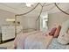 A well lit bedroom features a canopy bed, neutral decor, and wood floors at 285 Broadmoor Dr, Fayetteville, GA 30215