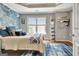 Bright bedroom boasts a water-themed wall, wooden floors, and natural light from the window at 285 Broadmoor Dr, Fayetteville, GA 30215