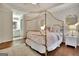 A well lit bedroom features a canopy bed, neutral decor, and wood floors at 285 Broadmoor Dr, Fayetteville, GA 30215