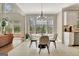 Bright dining area featuring a modern chandelier and a view of the wooded backyard through large windows at 285 Broadmoor Dr, Fayetteville, GA 30215