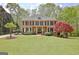 Charming two-story brick home with manicured lawn, mature trees, and classic black shutters at 285 Broadmoor Dr, Fayetteville, GA 30215