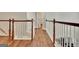 Upstairs hallway with wood floors and a view to the stairwell at 285 Broadmoor Dr, Fayetteville, GA 30215