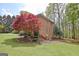 Large brick home with meticulously manicured landscaping and a vibrant red Japanese maple tree at 285 Broadmoor Dr, Fayetteville, GA 30215