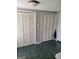 Hallway with neutral walls, green tile flooring, and a set of louvered closet doors at 4365 Newton Cir, Douglasville, GA 30134