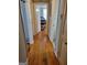 Hallway with wood floors featuring a view into a bedroom with shoe storage and a window at 4365 Newton Cir, Douglasville, GA 30134