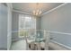Formal dining room with glass table and natural lighting from large window at 12711 Simmons Rd, Hampton, GA 30228