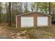 Two car detached garage with neutral colors and white doors at 12711 Simmons Rd, Hampton, GA 30228