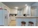 Bright kitchen features white cabinets and appliances, with a breakfast bar and seating at 12711 Simmons Rd, Hampton, GA 30228