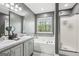 Bathroom with double sinks, separate shower, and jacuzzi tub under a window at 2014 Big Cypress Ln, Locust Grove, GA 30248