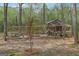 View of chicken coop with covered outdoor space in wooded backyard at 2014 Big Cypress Ln, Locust Grove, GA 30248