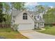 Charming home with a two-car garage, dormer windows, and a well-maintained lawn with mature trees at 2014 Big Cypress Ln, Locust Grove, GA 30248