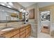 Bathroom featuring double sinks with wood cabinets, an oversized mirror, and a walk-in closet at 3230 Riverhill Ct, Cumming, GA 30041
