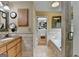 Bathroom with double sinks and cabinets, an adjacent bathtub, and a walk-in closet at 3230 Riverhill Ct, Cumming, GA 30041