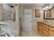 Bathroom featuring walk-in shower with glass door, custom vanity with granite counters, and a linen closet at 3230 Riverhill Ct, Cumming, GA 30041