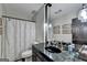 Bathroom with a black marble countertop, pendant lights and patterned shower curtain at 3230 Riverhill Ct, Cumming, GA 30041