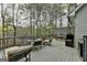 Spacious wooden deck with comfortable seating and outdoor dining area, surrounded by a serene wooded landscape at 3230 Riverhill Ct, Cumming, GA 30041