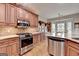 Modern kitchen with stainless steel appliances, wood cabinets, and granite countertops at 3230 Riverhill Ct, Cumming, GA 30041