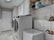Well-equipped laundry room with modern washer, dryer, storage cabinets, and tiled floors at 3230 Riverhill Ct, Cumming, GA 30041