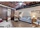 Living room featuring exposed wood ceiling, ceiling fan, barn door, wood-look laminate flooring, and comfortable furniture at 3230 Riverhill Ct, Cumming, GA 30041