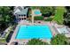 An inviting community pool area with lounge chairs and lush landscaping with building on the background on a sunny day at 3230 Riverhill Ct, Cumming, GA 30041