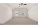 Spacious carpeted bedroom featuring a tray ceiling, fan, and large windows providing great natural light at 8593 Secretariat Dr # 20, Lithonia, GA 30058