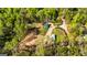 Aerial shot of property featuring a vibrant green home, pool, outbuilding, and surrounding lush, mature trees at 168 Lakeview Dr, Grantville, GA 30220