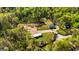 Overhead shot of verdant property with a green home, pool, separate garage, and surrounding dense, mature trees at 168 Lakeview Dr, Grantville, GA 30220