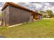 A rustic brown barn with an open storage area sits on a lush green lawn, blending functionality with charm at 168 Lakeview Dr, Grantville, GA 30220