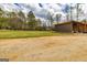 View of a green guest house with a wooden deck and a large open barn-like structure with ample space at 168 Lakeview Dr, Grantville, GA 30220