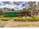 Charming green home featuring a covered porch, landscaped garden, and quaint walkway at 168 Lakeview Dr, Grantville, GA 30220
