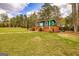 Quaint green guest house featuring a wooden deck nestled on a sprawling lawn, perfect for relaxation at 168 Lakeview Dr, Grantville, GA 30220
