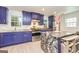 A modern kitchen features a marble-top island with seating and stainless steel appliances and lots of windows at 168 Lakeview Dr, Grantville, GA 30220