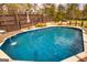A pristine in-ground pool is surrounded by a wooden deck, with a hot tub and wooded area in the background at 168 Lakeview Dr, Grantville, GA 30220