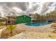A pristine in-ground pool with surrounding stone and a grassy yard, with the home in the background at 168 Lakeview Dr, Grantville, GA 30220