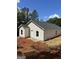 New house with a dark roof and light siding, showing the rear elevation, on a partially cleared lot at 543 Courthouse Park Dr., Temple, GA 30179