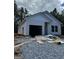 New construction home features an attached two-car garage and a white exterior, surrounded by a wooded lot at 543 Courthouse Park Dr., Temple, GA 30179