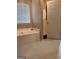 Bright bathroom features a soaking tub with a window, alongside a shower at 1132 Saint Phillips Ct # 90, Locust Grove, GA 30248