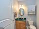 Cozy bathroom featuring a vanity with a green countertop, wall mirror, and toilet, creating a functional space at 170 Austin Oaks Dr, Ellenwood, GA 30294