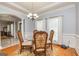Elegant dining area with a glass table, ornate chairs, and wainscoting detail at 170 Austin Oaks Dr, Ellenwood, GA 30294