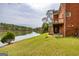 Brick home with a lake view, a wooden deck, steps and a green lawn at 170 Austin Oaks Dr, Ellenwood, GA 30294