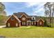 Beautiful two-story red brick home with manicured lawn and mature trees at 170 Austin Oaks Dr, Ellenwood, GA 30294